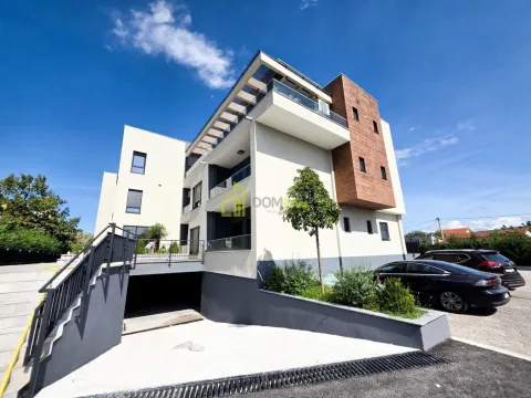 View of the exterior of a modern residential building with parking and a garage entrance. - image 11