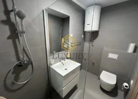 Modern bathroom with a shower cabin, washbasin, and toilet. - image 7