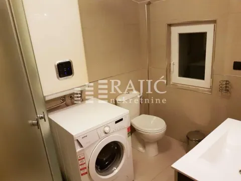 Smaller bathroom with a washing machine, toilet, and sink. - image 12