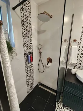 Moderno kupatilo sa tuš kabinom i crno-belim pločicama. - image 11