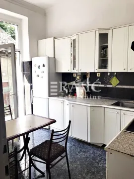 White kitchen with dining table and access to the terrace. - image 5
