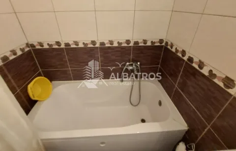 Bathroom with a white bathtub and brown and beige ceramic tiles. - image 7