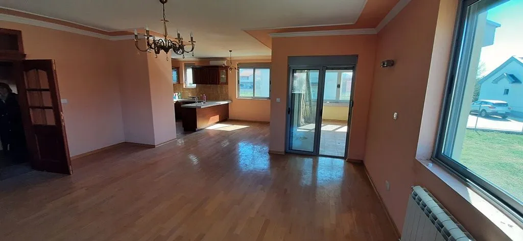 Spacious living room with wooden flooring and access to the terrace.