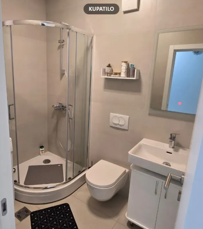 Savremeno opremljeno kupatilo sa tuš kabinom, umivaonikom i WC šoljom.