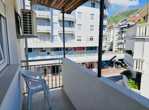 Manji natkriveni balkon sa stolicama i pogledom na gradske zgrade. - image 9