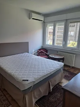 Spavaća soba sa bračnim krevetom, klima uređajem i prozorom sa pogledom na ulicu. - image 13