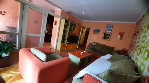 A living room with orange walls and colorful furniture. - image 4