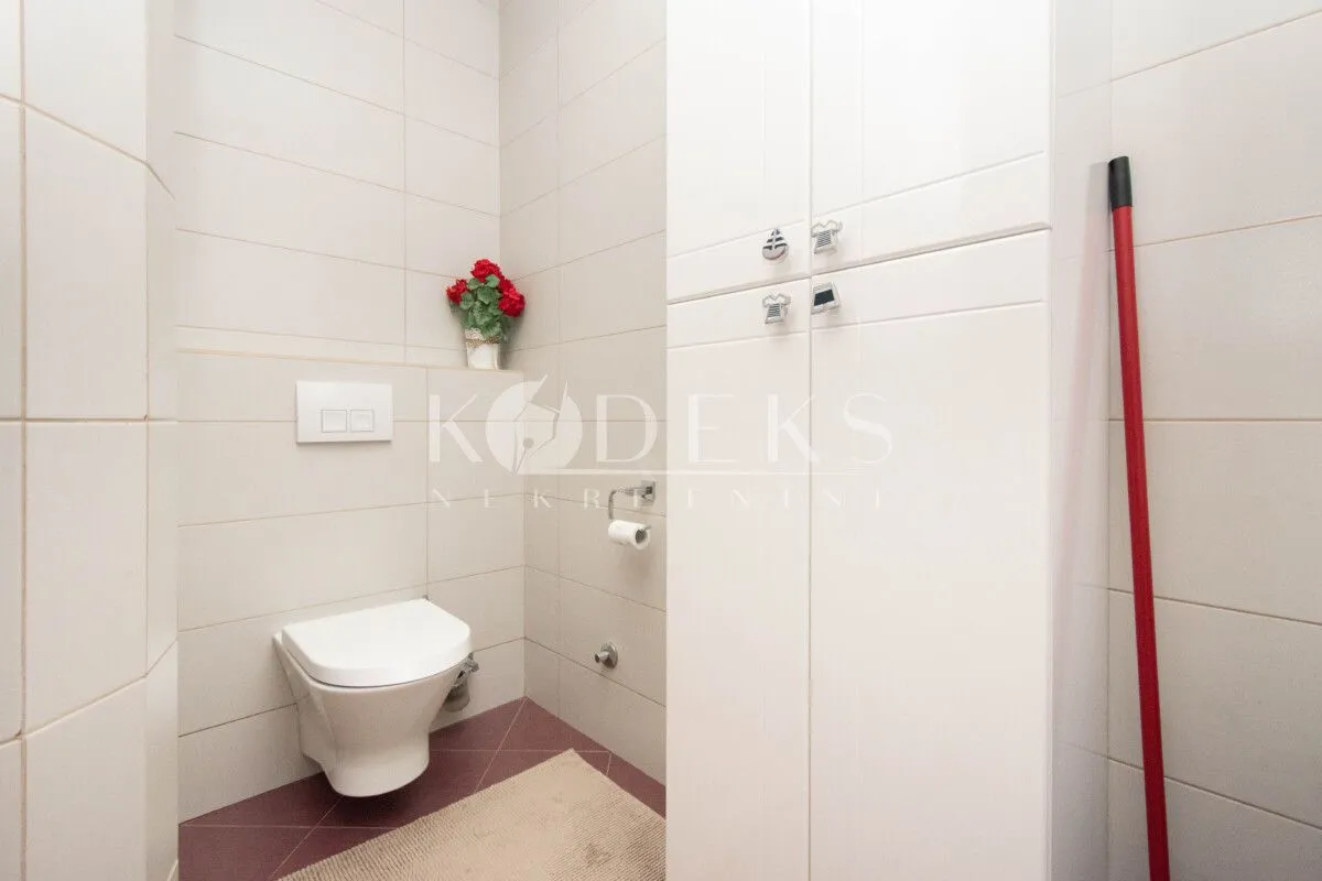 Smaller bathroom with white tiles and built-in units.