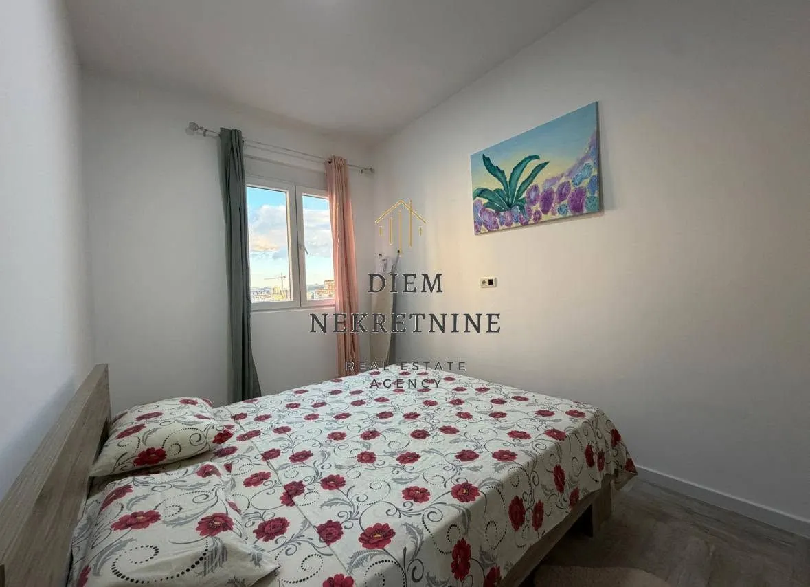 Furnished bedroom with a double bed and a window.