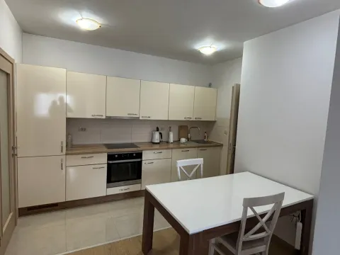 Kitchen with light-colored cabinets and a dining table. - image 4