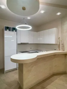 Moderna kuhinja sa bijelim elementima i šankom. - image 10