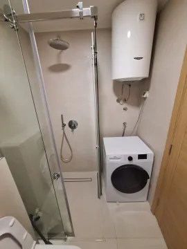 Modern equipped bathroom with a shower cabin and washing machine. - image 7
