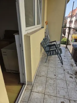 Small balcony with ceramic tiles and chairs, overlooking neighboring buildings. - image 12