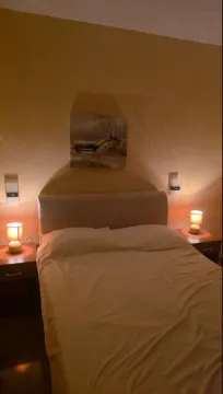 Furnished bedroom with a double bed and nightstands with lamps. - image 16