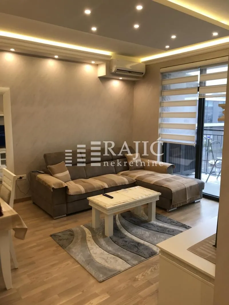 Furnished living room with a corner sofa and TV unit.