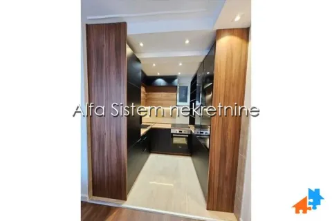A view of a modern equipped kitchen with dark elements and wood paneling. - image 8
