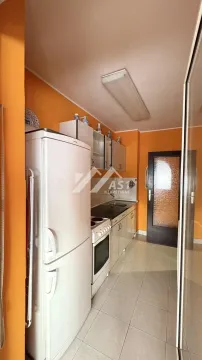 Manja kuhinja sa belim elementima i narandžastim zidovima. - image 3