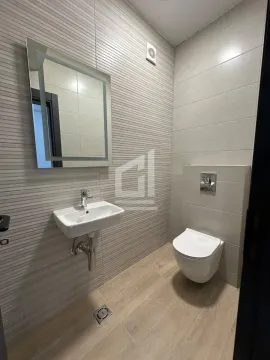 Moderno opremljeno kupatilo sa umivaonikom, ogledalom i toaletom. - image 5