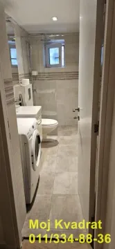 Pogled na kupatilo sa tuš kabinom, umivaonikom i veš mašinom. - image 4