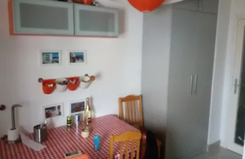 Trpezarija sa stolom i crveno-bijelim kariranim stolnjakom. - image 5