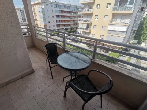 Balkon sa stolom, dvijema stolicama i pogledom na okolne zgrade. - image 6