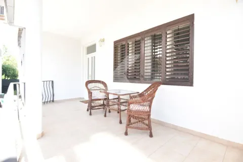 Covered terrace with wicker furniture and windows with shutters. - image 10