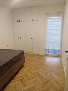 Svjetla spavaća soba sa ugradnim plakarom, krevetom i parketom u riblju kost. - image 7