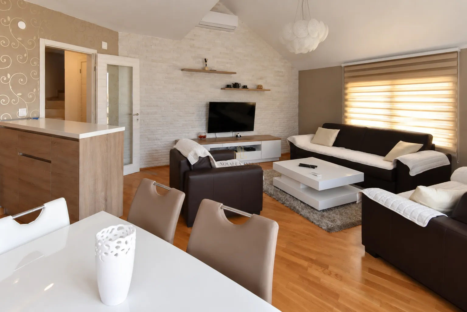 Living room with a sofa set, television, and dining table in the attic.