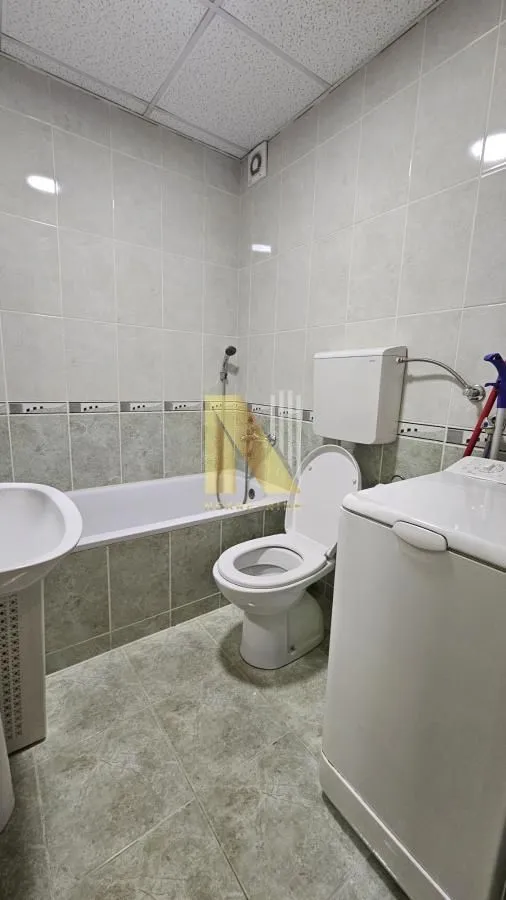 Kupatilo opremljeno kadom, wc šoljom, umivaonikom i veš mašinom.