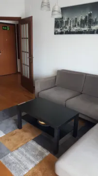 Living room with a sofa, coffee table, and a wall painting. - image 6