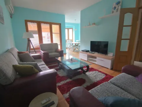 Svijetla dnevna soba sa garniturom za sjedenje i televizorom. - image 2