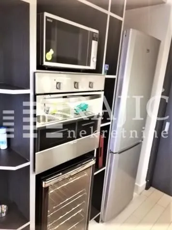 Modern kitchen with built-in appliances and a refrigerator.