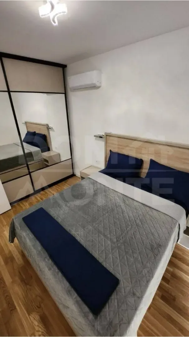 Furnished bedroom with a double bed, wardrobe, and air conditioning.