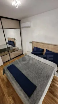Furnished bedroom with a double bed, wardrobe, and air conditioning. - image 4