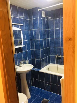 Kupatilo sa plavim pločicama i kadom. - image 2
