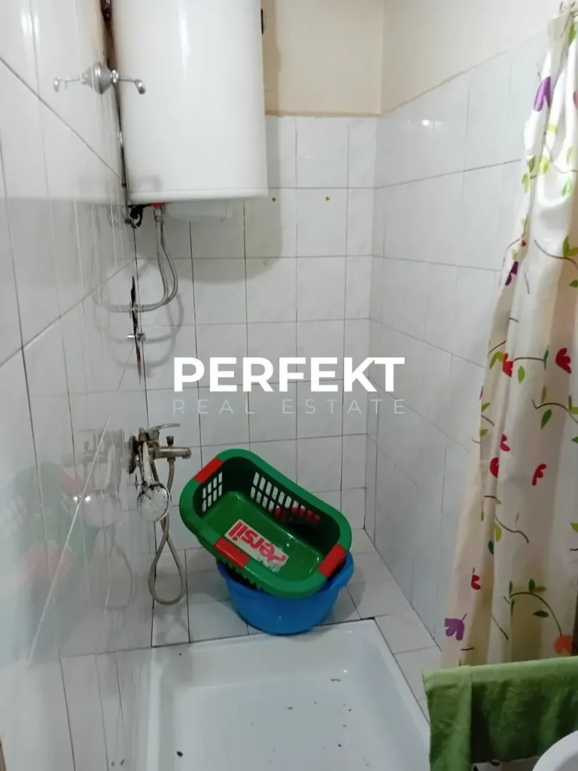 Manje kupatilo sa tuš kabinom i bojlerom.