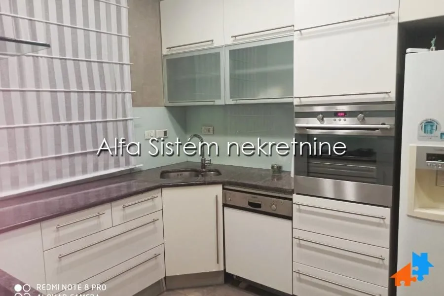 Kitchen equipped with white cabinets and built-in appliances.