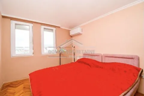 Simple bedroom featuring a double bed with a red cover. - image 6