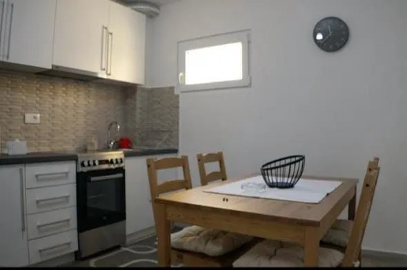 Small kitchen with a dining table and white cabinets.