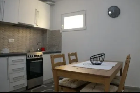 Small kitchen with a dining table and white cabinets. - image 5
