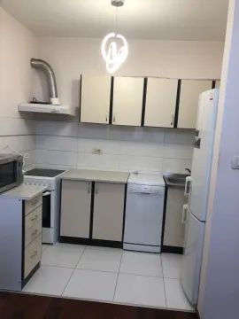 A simple kitchen with white cabinets and household appliances. - image 4