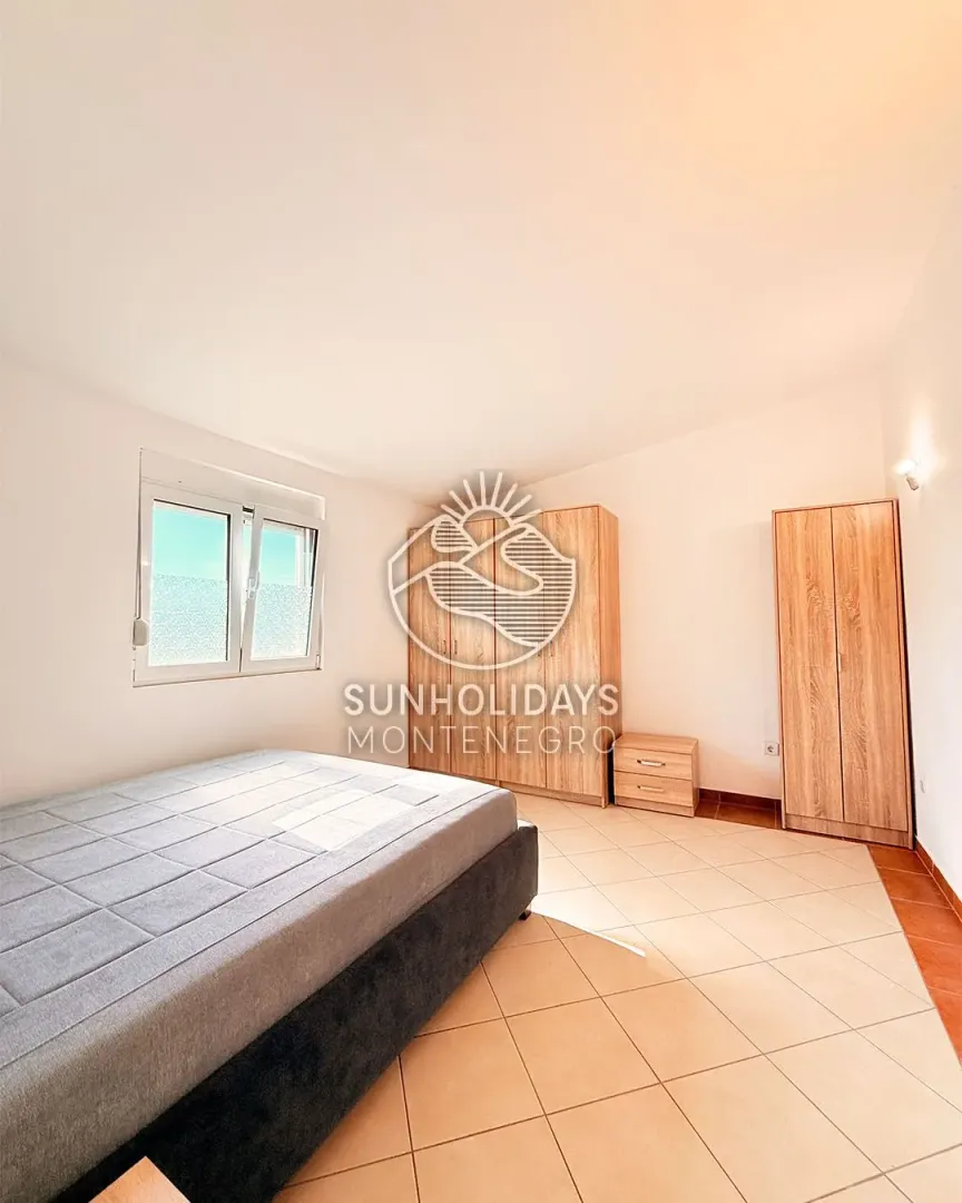 Furnished bedroom with a double bed and wooden wardrobes.