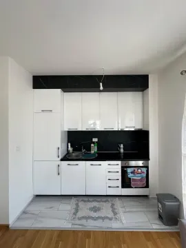 Manja kuhinja sa bijelim elementima i crnom radnom površinom. - image 4