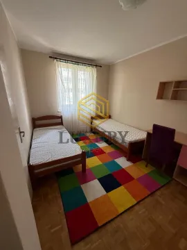 Children's bedroom with two single beds and a colorful rug. - image 4