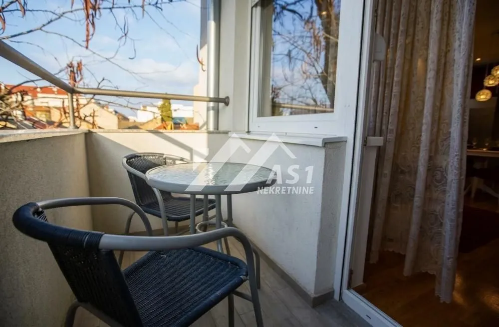 Manji namešteni balkon sa stolom i dve stolice.