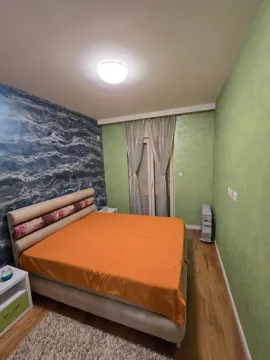 Spavaća soba sa bračnim krevetom i zelenim zidovima. - image 4