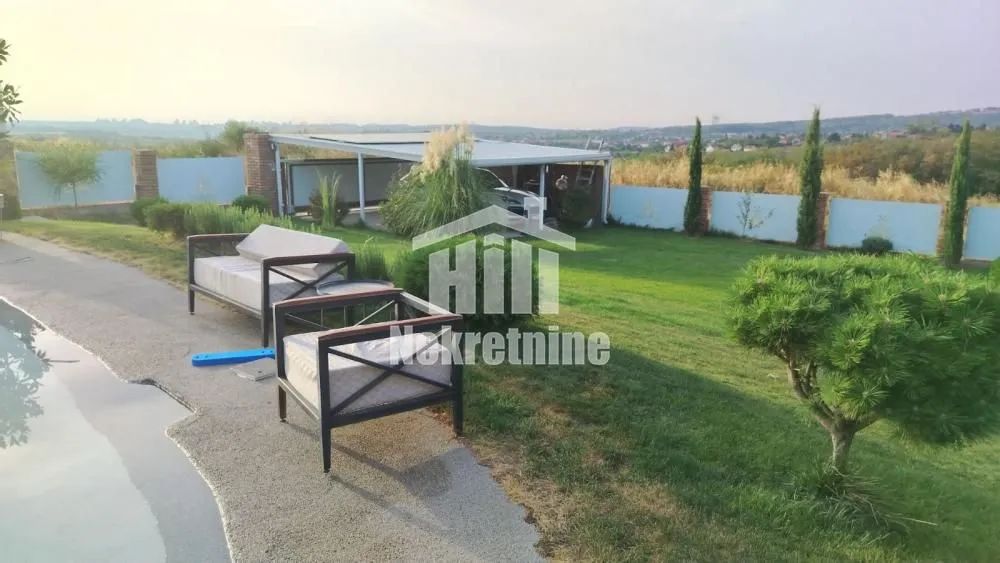 Landscaped yard with lawn, seating furniture and surrounding view.