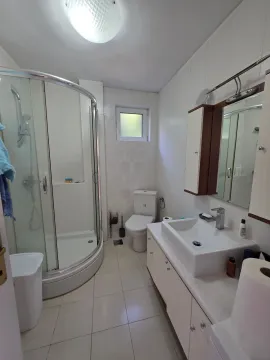 Kupatilo opremljeno tuš kabinom, umivaonikom sa ormarićem i toaletom. - image 14