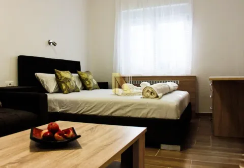Furnished bedroom with a double bed, pillows, and folded towels. - image 7