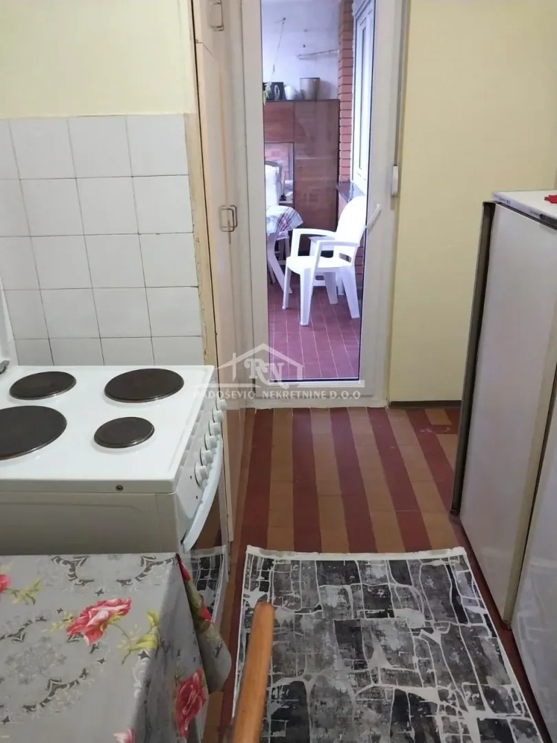 Manja kuhinja sa štednjakom i izlazom na terasu.